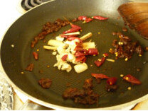 5、家庭版水煮鱼,加入佐料C的姜丝、蒜泥、花椒、干辣椒，翻炒出香味