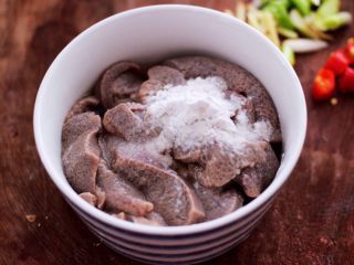 5、土匪猪肝,把冲洗干净的猪肝，沥干水分放入碗里，加入淀粉和4克料酒抓匀。