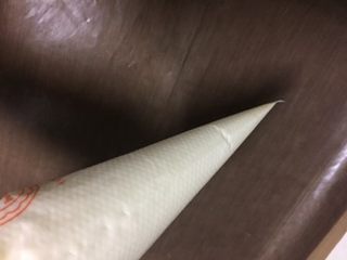 10、蓝天白云蛋糕卷,把翻拌均匀的蛋糕糊装进一个裱花袋，裱花袋前端剪一个小口。