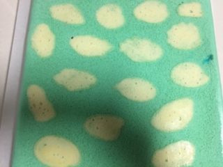 17、蓝天白云蛋糕卷,蛋糕出炉轻摔两下，连同油布把蛋糕拖至晾网架冷却，准备一张油纸把蛋糕倒扣在油纸上轻松撕去油布。