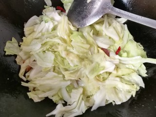 9、腊肠手撕包菜,炒至包菜变软时，再调入适量盐炒均匀；