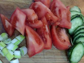 2、西红柿鸡汤面,如图西红柿洗净切块，黄瓜洗净切片，葱切葱花