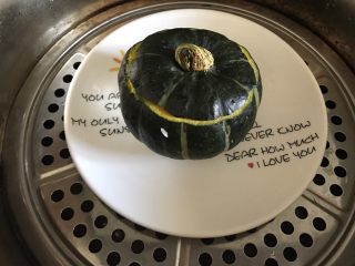 9、一人食 南瓜杂粮饭,盖上南瓜盖，将南瓜放在一个盘子上，蒸锅加满水