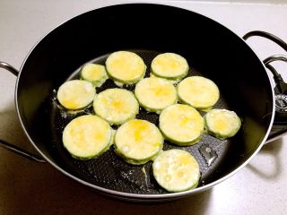 9、香煎西葫芦鸡蛋饼,锅内加入少许大豆色拉油烧热，加入裹好淀粉和鸡蛋液的西葫芦片，小火煎制