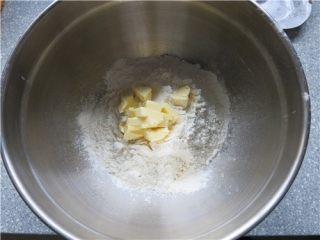 4、超快速面包--切达芝士香葱司康,泡打粉与面粉过筛到容器里，黄油切成块放在面粉上面,黄油不要软化冰箱取出来就用。