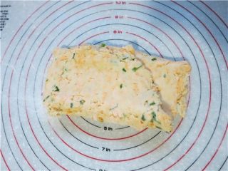 11、超快速面包--切达芝士香葱司康,硅胶案板上撒薄面将面团至于案板上，采用擀开折叠按压的方法折叠2次，不要用手揉。