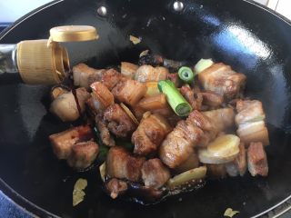 13、红烧肉,倒入生抽3勺,老抽1勺,黄酒1小碗,翻炒均匀。