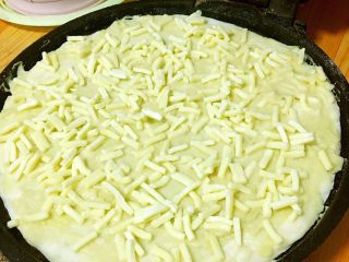 4、榴莲芝士火焰薄饼,把擀好的饼放到电饼铛里，涂上一层榴莲肉，上面撒上一层芝士。