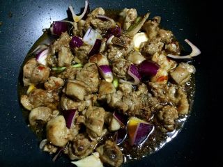 9、胡萝卜烧土鸭,加入洋葱和蒜瓣、小葱翻炒均匀。