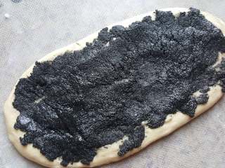 5、芝麻酱花纹吐司,取出面团排气揉圆擀开，面团上摊满馅料，用勺子的背面简单摊平