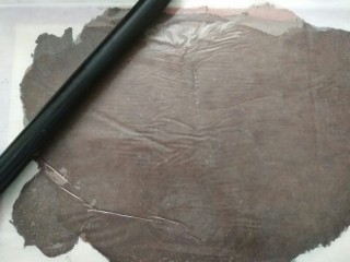 3、#不一样的泡芙#酷黑的黑森林泡芙,将面团放在硅胶垫上，盖上油纸擀成薄片