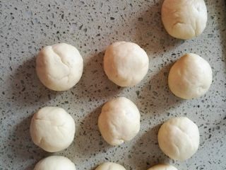 2、莲蓉馅花朵面包,面包桶中进行发酵。发酵完成排气，搓成大小相同的小面团。静置10-15分钟。（加盖保鲜膜。）