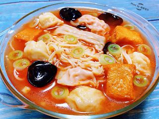 9、#冬日暖心菜#番茄金针菇汤,番茄金针菇小丸子汤装入容器中撒上葱花就大功告成了