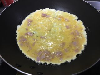 2、「吃货久久」小森日系鸡蛋卷升级版,平底锅中火倒入油 油越多越好 鸡蛋就越嫩 我不太爱吃重油的食物 所以刚好平铺锅底。倒入一半蛋糊。