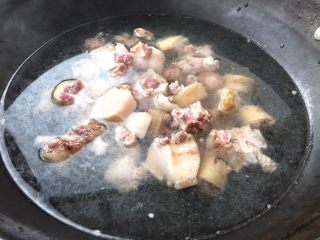 3、美容养生汤～黄豆炖猪尾,倒入剁好的猪尾入水焯几分钟，焯水可以去除猪尾腥味儿。