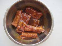 4、微波红酒排骨,将排骨放入调好的腌料汁中,再磨入少许黑胡椒粉拌匀按摩一会。