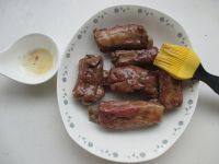 9、微波红酒排骨,取出排骨,打开放在盘中,观察一下排骨的成熟程度,其中口感外表筋道一点的,可去掉纸直接放在盘中,微波高火两分钟,翻面,再两分钟。喜欢嫩一点的,这步省略。直接用刷上刷上一层蜂蜜,进微波炉,高火一两分钟,翻面,再一两分钟。
