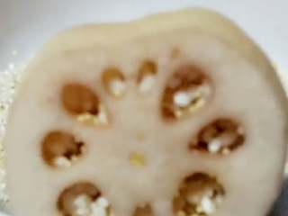 5、蜜汁桂花藕,糯米用过滤布沥干水分倒入容器中，往藕孔里罐，尽量把每个孔都罐入8分满。