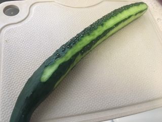 1、一夜渍：爽口黄瓜条,黄瓜用刨子去皮，但不用全削完，留点线条更加美观；