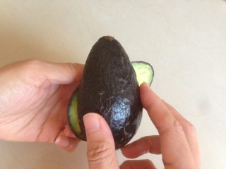 2、牛油果奶昔,双手分别握着牛油果的上下部分，反方向拧。