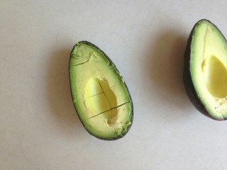 5、牛油果奶昔,用勺子沿着外皮，轻轻旋转，切成小块状。