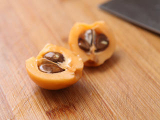 3、枇杷果酱,光溜溜去了皮的枇杷，用刀对半划一刀，扭一下，分成两半。