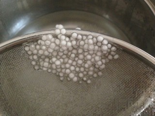 3、牛奶芒果西米露,10分钟后的西米周围已出现透明状了，将有点结团的西米搅拌开，再将水煮开，关火，盖盖子焖十分钟。