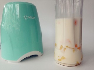 5、牛奶芒果西米露,芒果肉，牛奶，方糖放进便携式果汁机的杯子里。