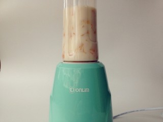 7、牛奶芒果西米露,将杯子安装在果汁机的底座上，打开电源。