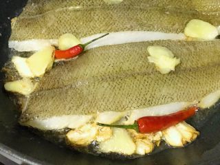 10、烧比目鱼柳,在加入蒜片，煎香。