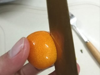 6、糖渍金桔,取一颗小金桔，像我这样不切断，切4至5刀