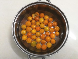 10、糖渍金桔,放到锅里，加水泡过金桔的一半桔身