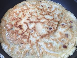 8、日式大阪烧,表面微微凝固后，翻面～小心一点，我这里翻破了，不过没关系，铺上料就看不见啦，吼吼！两面金黄起焦斑就可以出锅了。