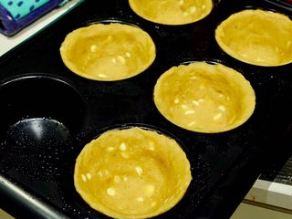 14、简单快手曲奇马芬杯,取一坨面图 将其按压进模具 注意⚠️底层要薄！两边要厚！ 因为烤后底部会鼓起来 烤箱预热170度 先烤15分钟