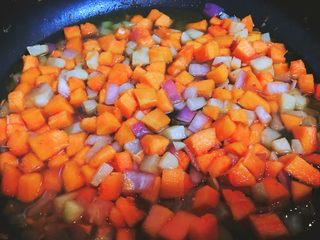 6、清甜解腻养脾胃的南瓜浓汤,翻炒一两分钟，加入适量清水，清水的量大概没过南瓜土豆洋葱丁的三分之一处就行