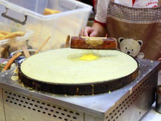 9、天津老味煎饼果子,一个鸡蛋，一磕一掰，落在煎饼上，“竹蜻蜓”把蛋黄敲散，然后把鸡蛋搅打成蛋液。