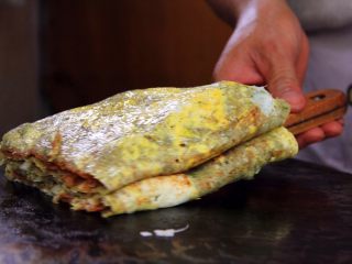 16、天津老味煎饼果子,用小铲子铲起热气腾腾的煎饼果子，装入袋子，送到你的眼前，有口福的尝尝吧。咬一口软糯松散沙沙口感的煎饼，每口都有鸡蛋，配上酥脆的果蓖儿，真是美味！