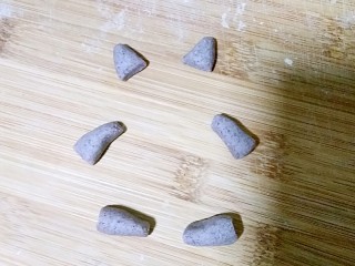 7、龙猫豆沙包,然后再揪适量的黑米发面团，搓成龙猫的耳朵，胳膊和腿。整个过程就像玩橡皮泥，家里有小宝儿的亲们，时间充裕的时候可以带宝宝一起做，很不错的家庭亲子活动。