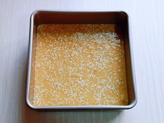 9、红糖枣糕别在外面买了～自己在家做～健康无添加,拌好的红枣枣泥糊倒入模具中，用刮刀刮平整，轻轻震几下，将气泡震出，再撒上白芝麻。