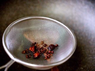 4、海鲜烩年糕,炸出香味以后、把炸过不用的花椒和八角捞出沥干丢掉