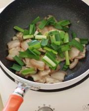 4、农家小炒肉,翻炒至五花肉变色，加入青蒜；