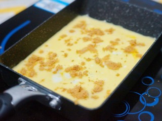 8、芝士肉松玉子烧,小火加热至蛋液底部开始凝固时，在表层均匀地撒上适量肉松。