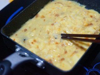 9、芝士肉松玉子烧,用筷子轻轻搅拌，划散蛋液。