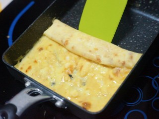 10、芝士肉松玉子烧,加热至半熟，借助刮刀卷起来。