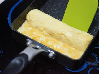 14、芝士肉松玉子烧,加热至半熟，借助刮刀卷起。