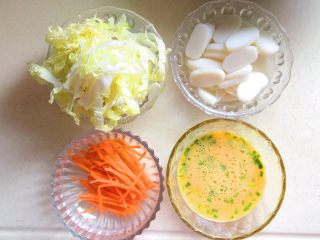 1、年年高,年糕切片，黄芽菜和胡萝卜切成丝，鸡蛋打散备用