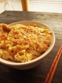 6、猪排丼,盛好一碗白米饭,把煮好的猪排连汤汁盖到白米饭上面,撒上一些七味粉,就好了。