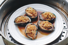 6、葱油鲍鱼,淋上调味料汁，水开后放入蒸锅内大火蒸3分钟即可关火。