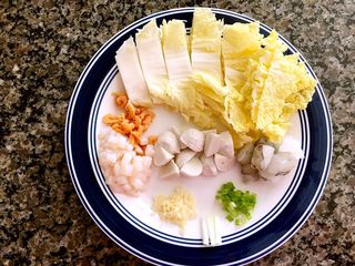 1、海鲜豆腐煲,#如图准备食材# 一定要好好洗海米,着重洗虾线,瑶柱反复过水,否则会有沙。别问我怎么知道的。瑶柱切丁,大虾切块,鱼丸切块,白菜切段,蒜切末,葱白切段,葱绿切花