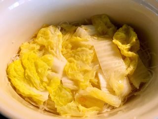 7、海鲜豆腐煲,将煮熟的长白菜夹起来铺在粉丝上备用
